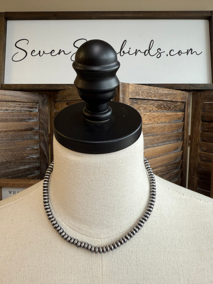 Silver-tone saucer beaded necklace on mannequin bust, 16-inch length.