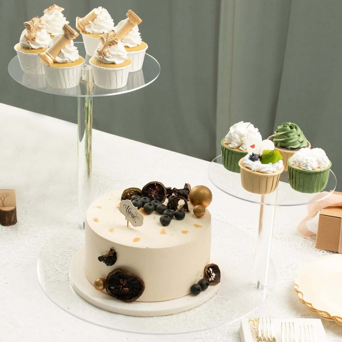 Decorative cake and cupcakes on clear stands for a festive celebration.