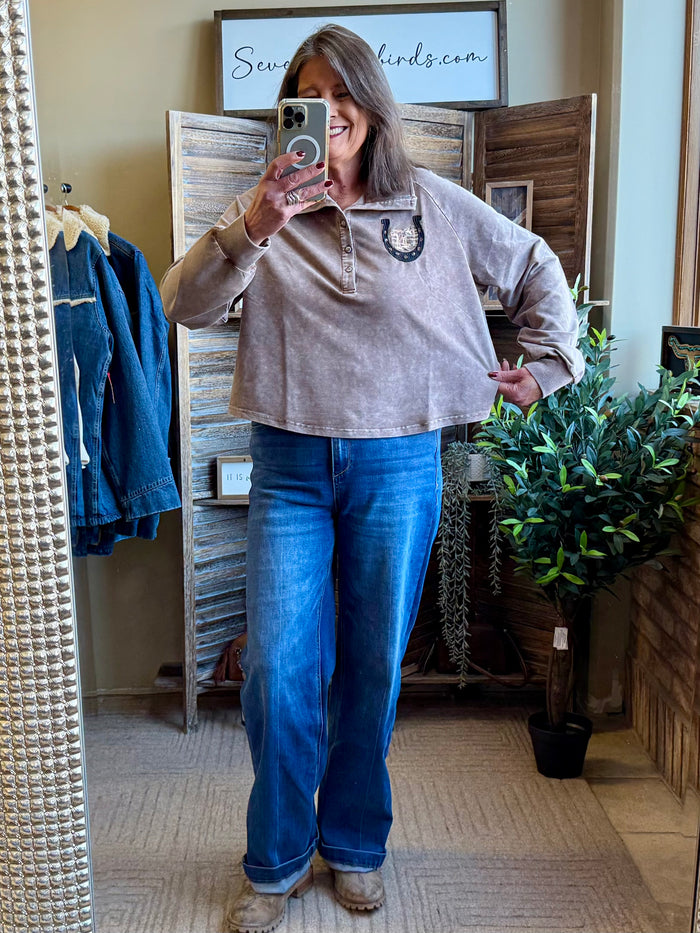 Light gray half-zip sweatshirt with dark embroidered horseshoe design