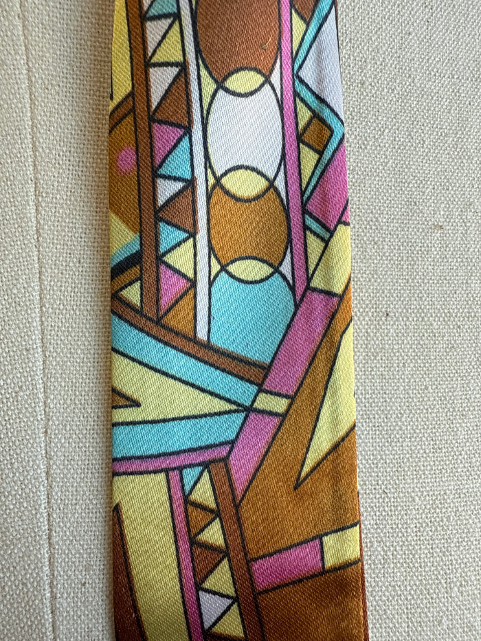 Geometric twilly scarf close-up with multicolor stained-glass pattern and circles