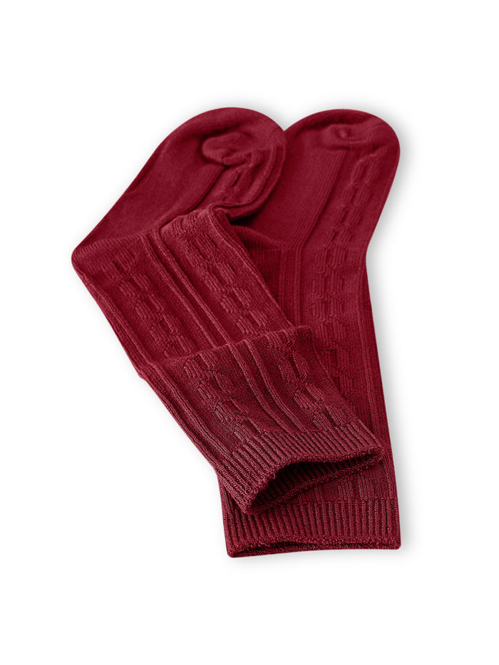 Knee high socks in ruby laying flat on a white background.