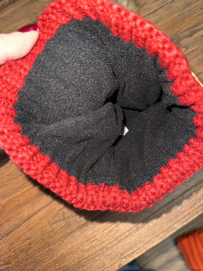 Red cable-knit beanie with black inner lining, folded brim