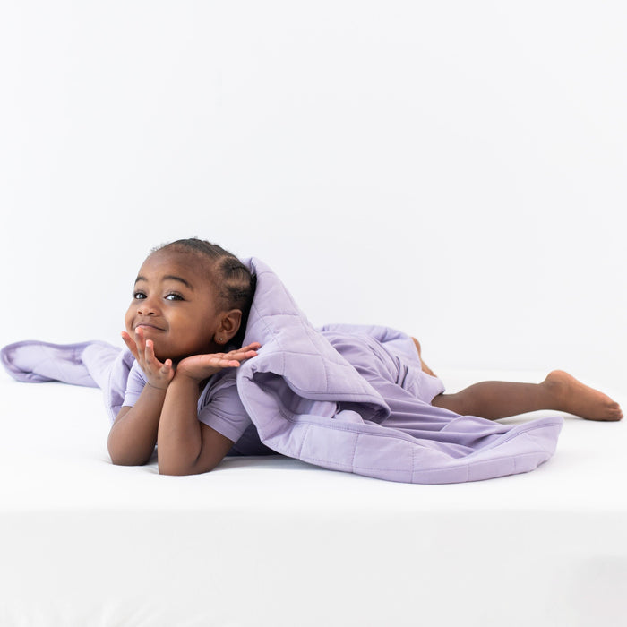 Child on tummy covered in a Toddler Blanket in Taro 2.5 TOG