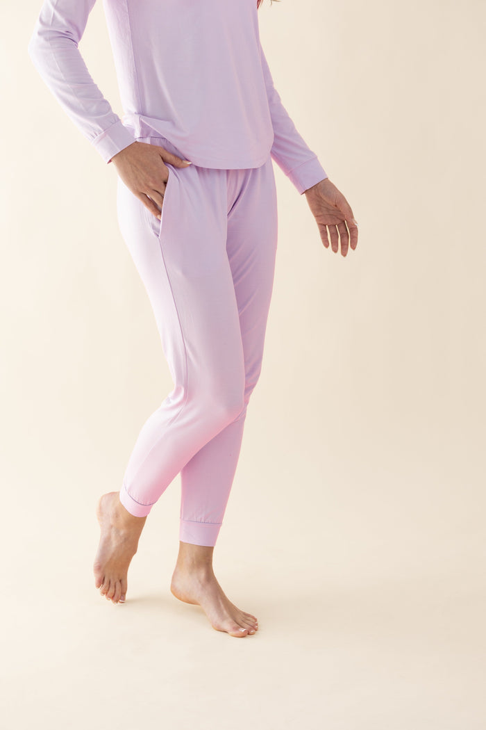 Person wearing light purple pajama set on a beige background