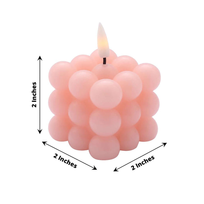 Pink bubble candle with a lit wick, measuring 2 inches in height and width.