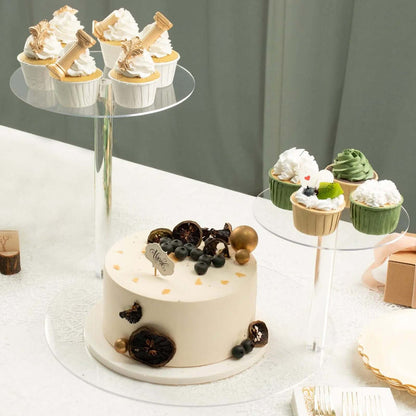 Decorative cake and cupcakes on clear stands for a festive celebration.