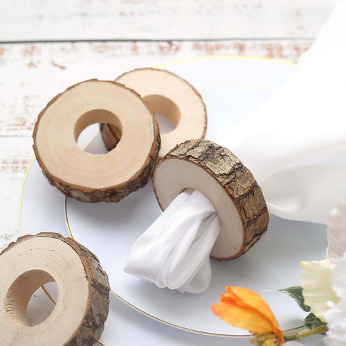 Rustic wooden napkin rings with white napkin on a decorative plate