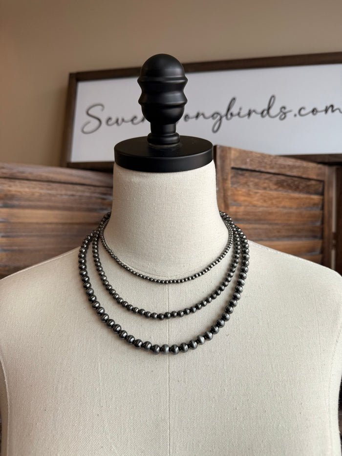 Silver-toned beaded necklace, double strand on mannequin bust