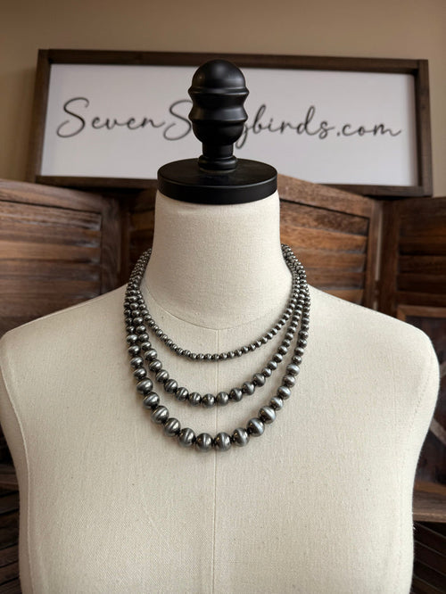Triple-layer pearl necklace with three rows of dark silver-toned beads