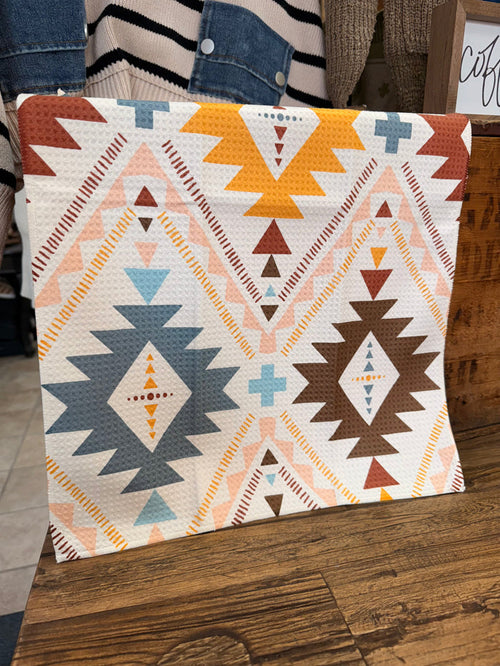 Cream Aztec patterned towel with geometric triangles, stars, and diamond accents in blue and orange.