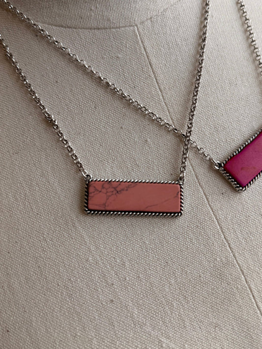 Stone bar necklace with brown rectangular pendant on silver chain; magenta pendant visible