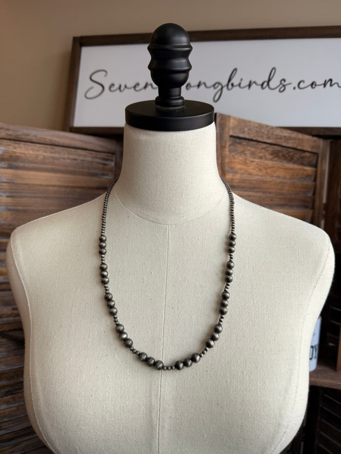 24-inch graduated dark pearl bead necklace on mannequin torso