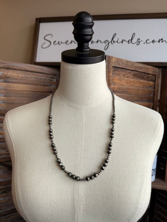 24-inch graduated dark pearl bead necklace on mannequin torso