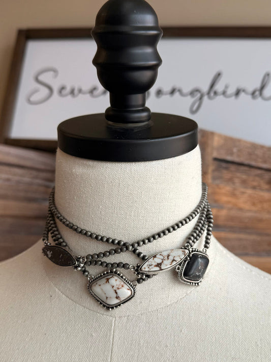 Stone pendant necklace with silver chain and oval/diamond charms in dark and white stones