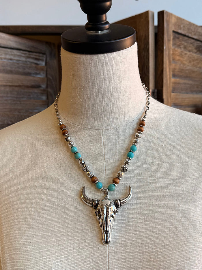 Cow skull pendant necklace with turquoise and brown bead strands and silver-tone skull