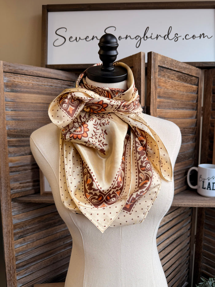 Tan wild rag scarf with orange-brown floral paisley print and border edges