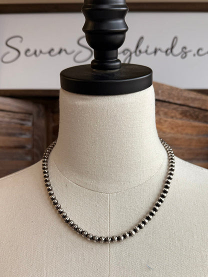 18-inch pearl necklace with dark 5mm round pearls, full length on display