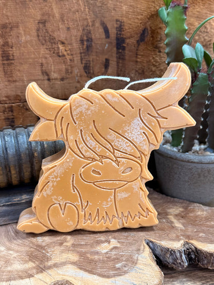 Gold highland cow candle close-up, detailed embossed face with wick