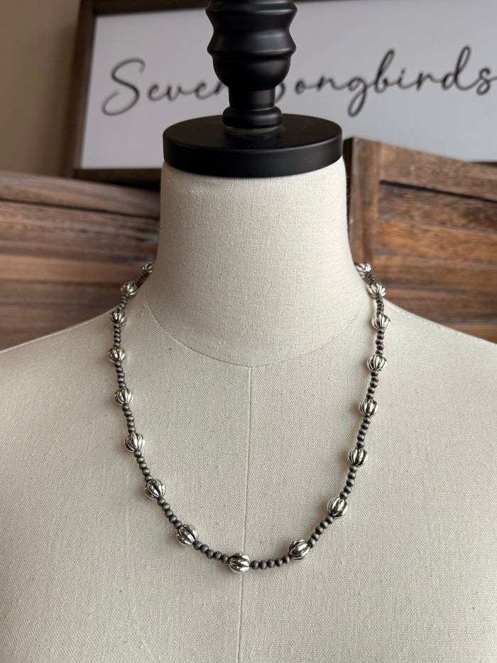 Pearl bead necklace on a mannequin, silver-tone beaded chain with rounded bead drops