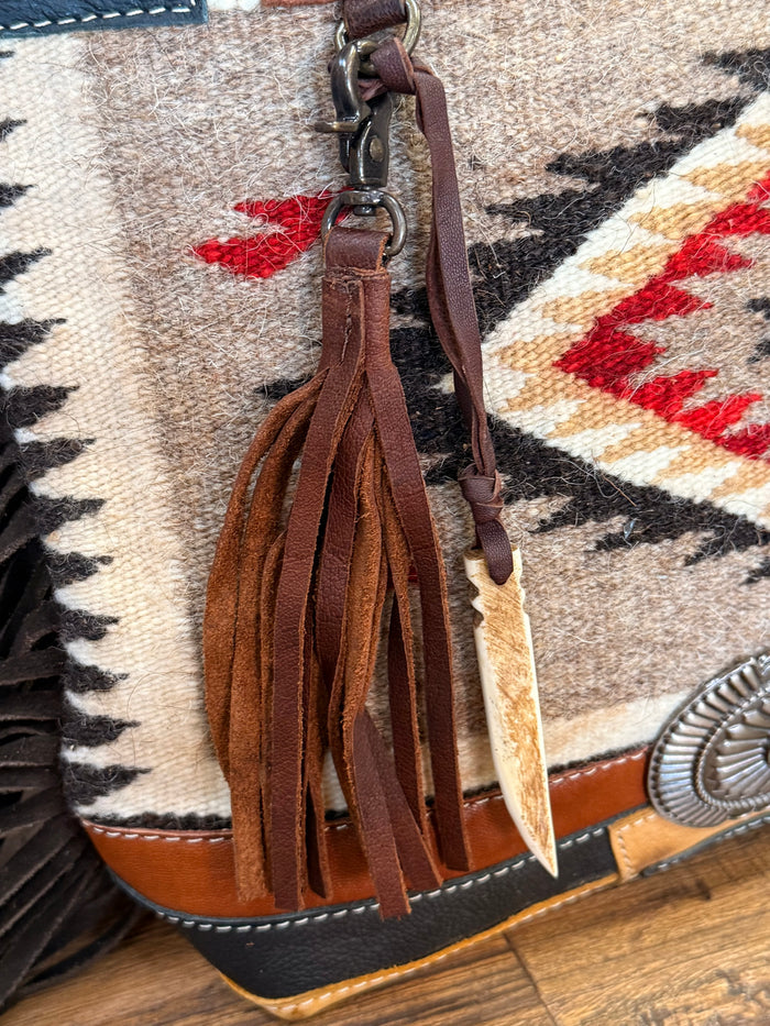 Woven wool crossbody purse with brown leather tassel fringe and metal clasp hardware