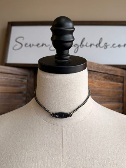 Stone pendant necklace with silver chain and centered oval dark pendant charm
