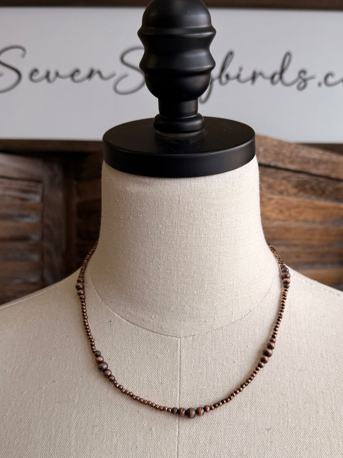 Graduated copper beaded necklace, 18 in, shown from slightly wider angle.