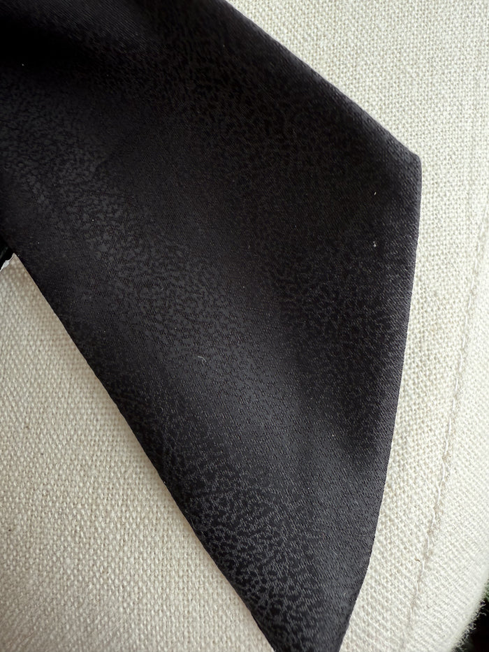 Black leather twilly scarf with textured surface, folded triangular shape and edge detail