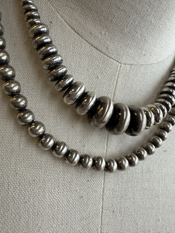 Double-layer shiny pearl necklace with metallic round beads, close-up detail