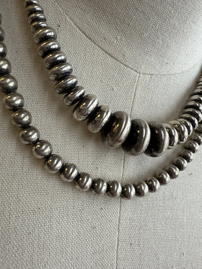 Double-layer shiny pearl necklace with metallic round beads, close-up detail
