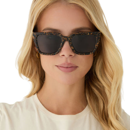 on model - blonde female wearing diff eyewear featuring the amara square sunglasses with a glitter tortoise frame and brown gradient polarized lenses front view