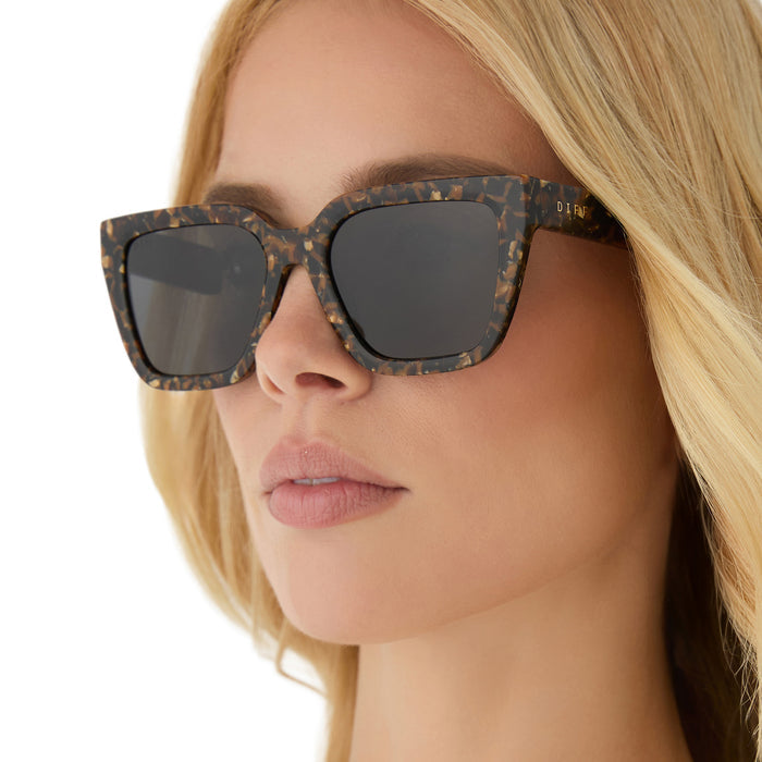 on model - blonde female wearing diff eyewear featuring the amara square sunglasses with a glitter tortoise frame and brown gradient polarized lenses angled view