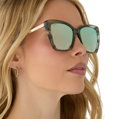 on model - female wearing diff eyewear featuring the becky ii cat eye sunglasses with a cool matcha green frame and cool matcha mirror lenses angled view
