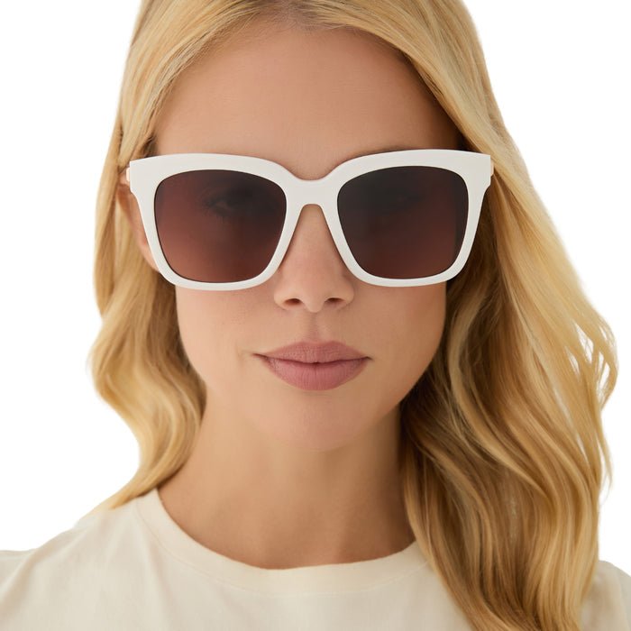 on model - blonde female wearing diff eyewear featuring the bella square sunglasses with a snowbound white frame and brown gradient lenses front view