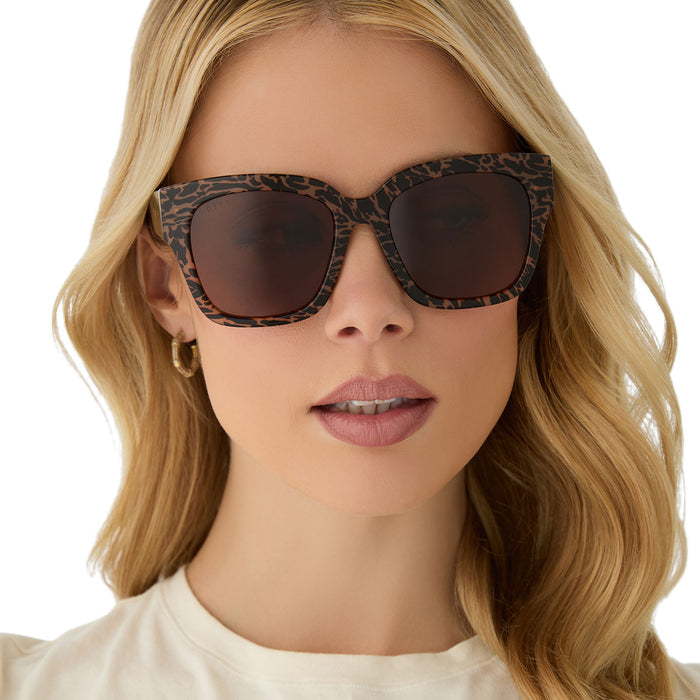 on model - female wearing diff eyewear featuring the bella ii square sunglasses with a animal print frame and brown lenses front view