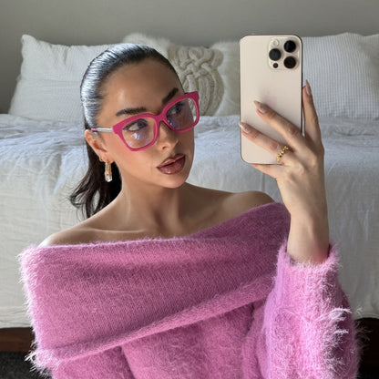 lifestyle - Emily Gordon Brunette influencer wearing light pink fuzzy off the should sweater with bright pink blue light glasses from diff eyewear