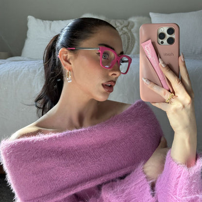 lifestyle - Emily Gordon Brunette influencer wearing light pink fuzzy off the should sweater with bright pink blue light glasses from diff eyewear
