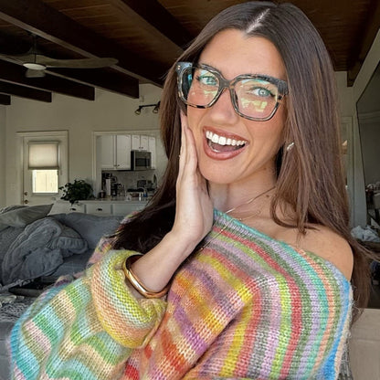 customer content - Sara Joy brunette influencer wearing tort square shaped  eyeglasses with rainbow striped off the should knit sweater