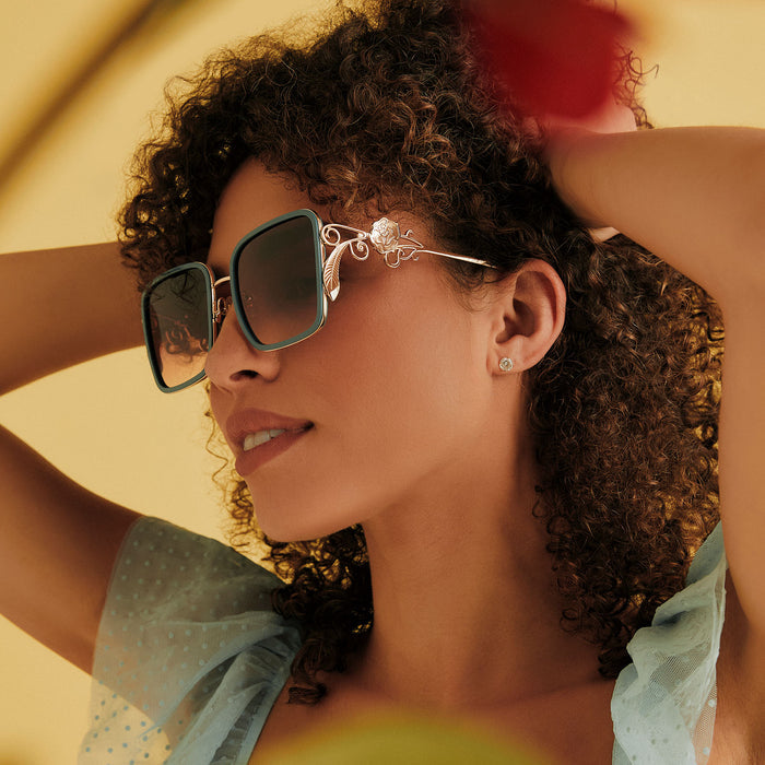on model - female wearing disney princess x diff eyewear featuring the belle 2.0 oversized square sunglasses with a gold and enchanting blue frame with brown gradient polarized lenses angled view