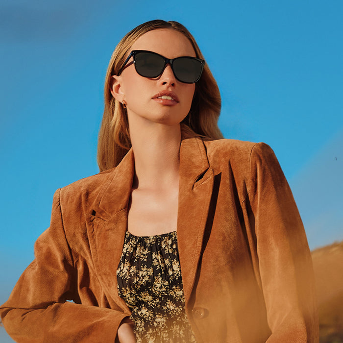 lifestyle - female wearing yellowstone x diff eyewear featuring the beth iii cat eye sunglasses with a black frame and grey lenses angled view