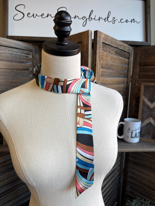Geometric twilly scarf in multicolor stripes, loosely tied on mannequin