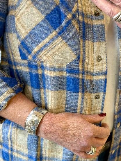 Close-up of blue and tan plaid shacket with button placket