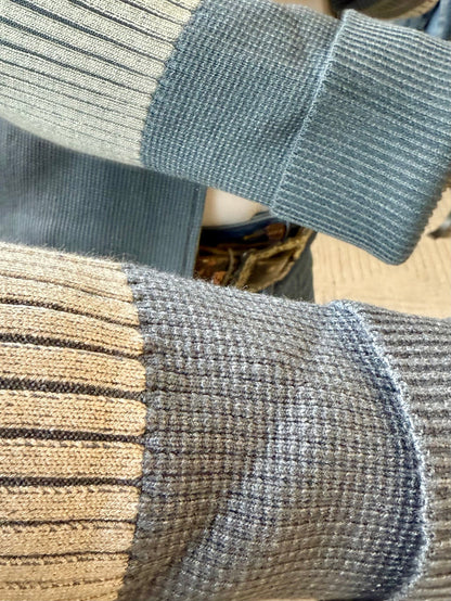 Close-up of ribbed knit cardigan cuffs and hem seam in mid blue