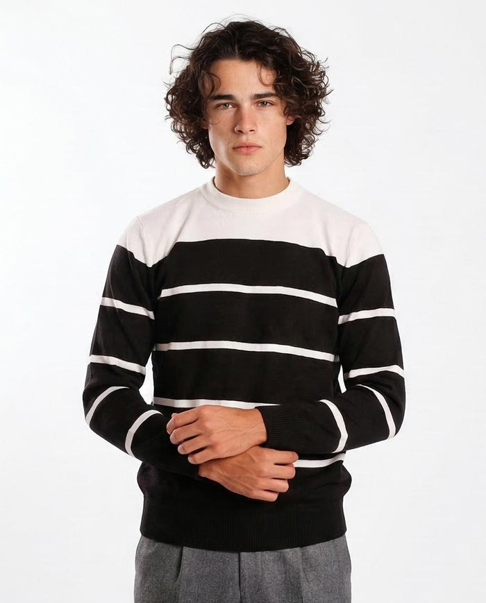 Person wearing a black and white striped sweater on a white background