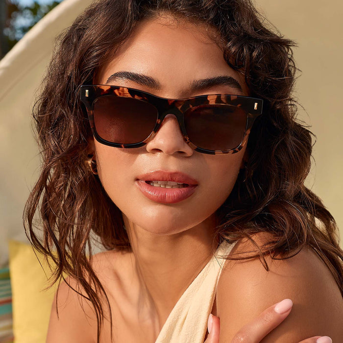 lifestyle - female outdoors wearing diff eyewear featuring the bradley cat eye sunglasses with a espresso tortoise frame and brown gradient polarized lenses front view