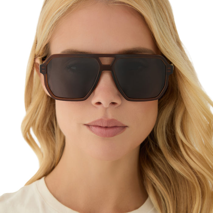 on model - blonde female wearing diff eyewear featuring the cameron navigator sunglasses with a whiskey brown frame and grey polarized lenses front view