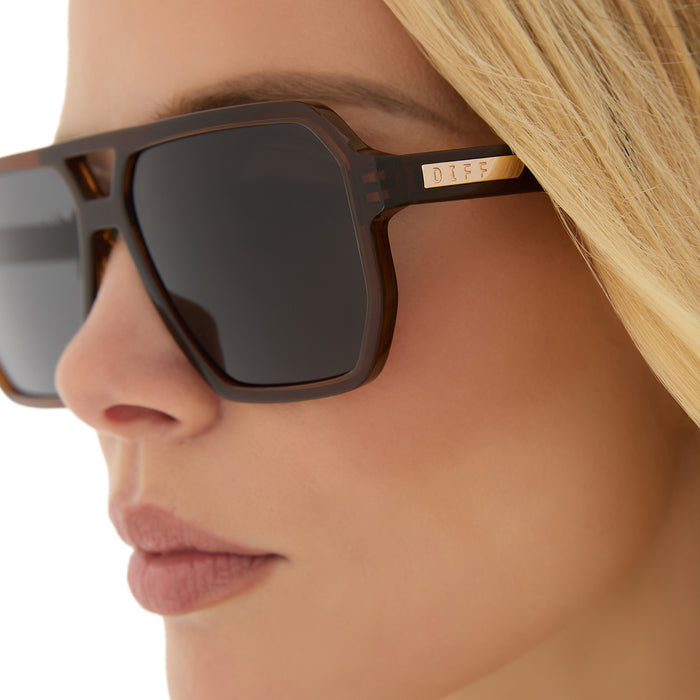 on model - blonde female wearing diff eyewear featuring the cameron navigator sunglasses with a whiskey brown frame and grey polarized lenses detailed view