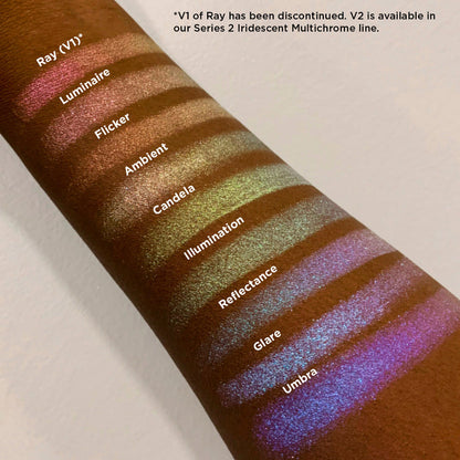 Left angled arm swatches on deep skin tone of Candela Iridescent Multichrome Eyeshadow shifts compared to Ray, Luminaire, Flicker, Ambient, Illumination, Reflectance, Glare, Umbra