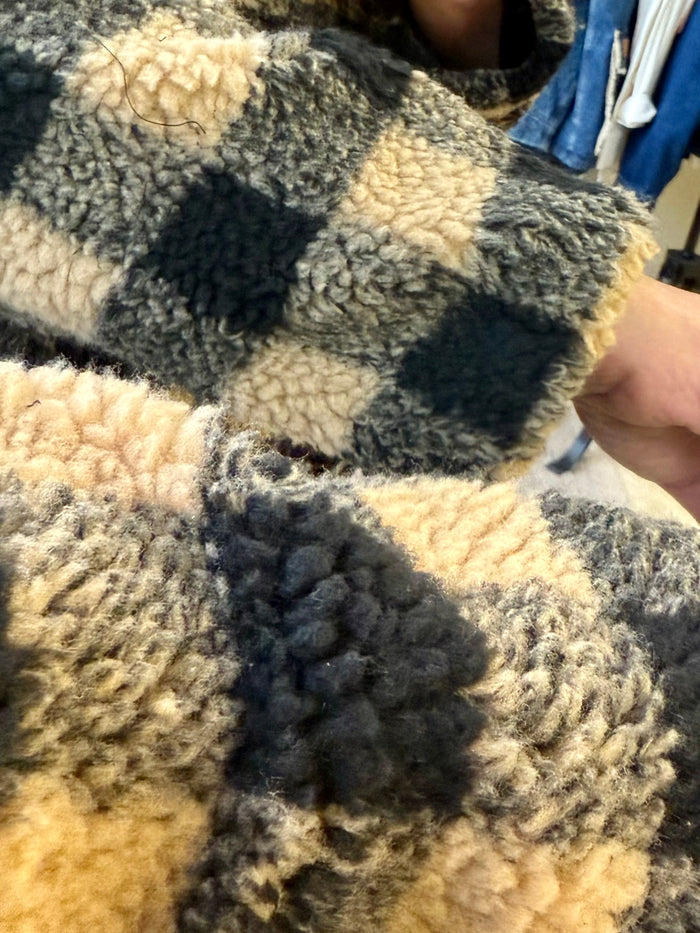 Sherpa checkered coat cuff with black, tan, and cream fuzzy texture