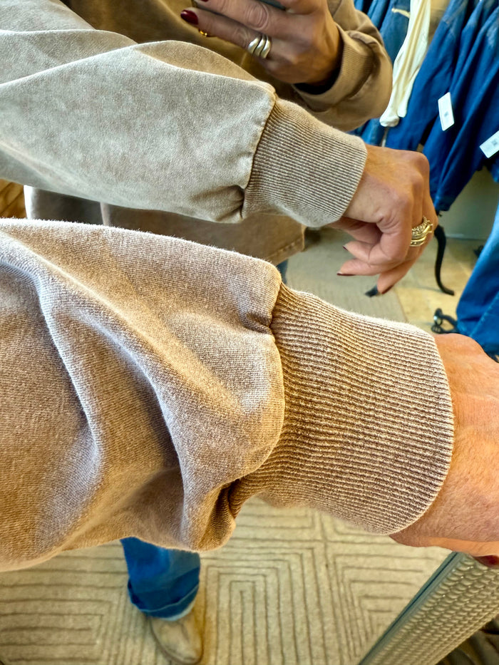Light gray sweatshirt sleeve with ribbed cuff and textured knit hem