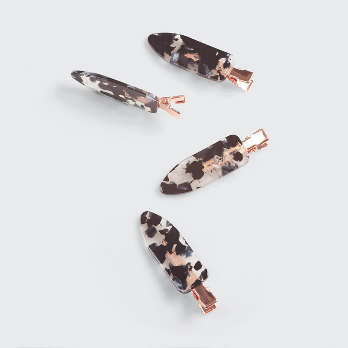 Four tortoise print Kitsch creaseless hair clips arranged on a gray background.